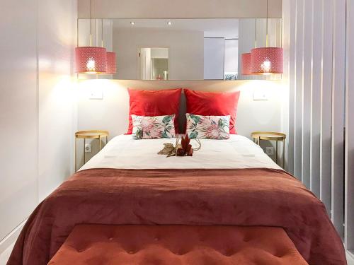 a bedroom with a large bed with red pillows at Casa Suyay Studio in Aveiro