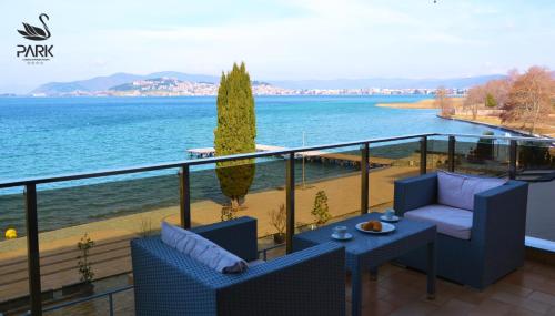 a balcony with two chairs and a table and the ocean at Park Lakeside Ohrid in Ohrid
