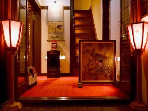 a hallway with a painting on the floor and two lights at Gionkoh in Kyoto