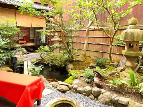 um jardim com um lago e uma casa de pássaros em Gionkoh em Quioto