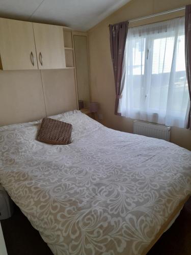 a bedroom with a large bed with a pillow on it at Pine Ridge 59 Rockley Park Poole with sea view sleeps six in Poole