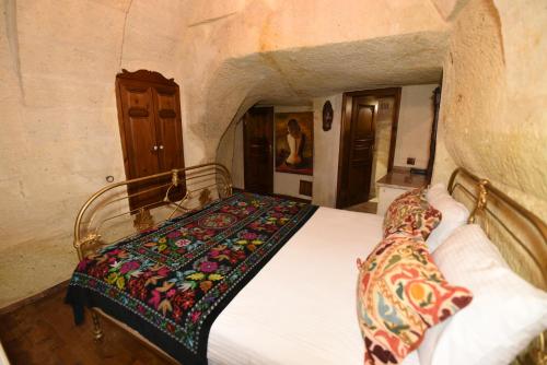 a bedroom with a bed in a stone room at Canela Cave Hotel - Cappadocia in Goreme