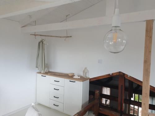 a kitchen with a white cabinet and a light at Villa Rena Agios Petros in Áyios Pétros