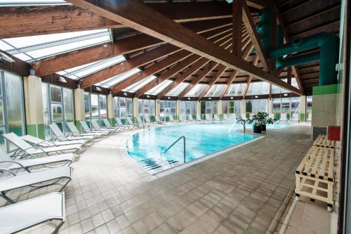 una piscina cubierta con sillas y un edificio en Lobios Caldaria Hotel Balneario, en Bubaces