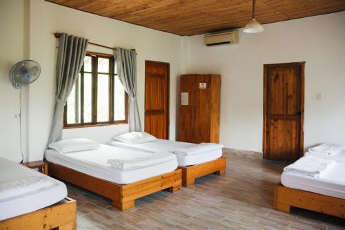 a room with three beds and a window at Villa Đảo Hoa Vàng Cam Ranh - Venuestay in Cam Ranh