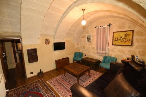 a living room with a couch and a table and chairs at Canela Cave Hotel - Cappadocia in Goreme