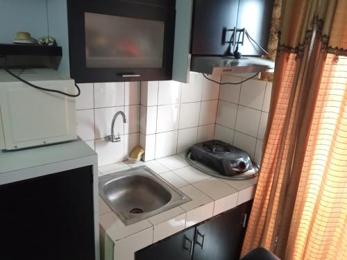 a small kitchen with a sink and a microwave at Adhigana Property Kemang View in Pekayon Satu
