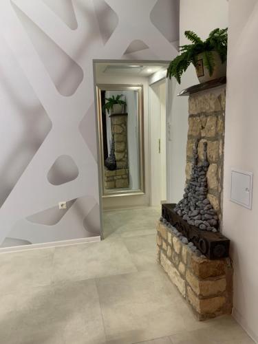 a room with a stone fireplace and a mirror at KARTAL centar apartment in Bihać