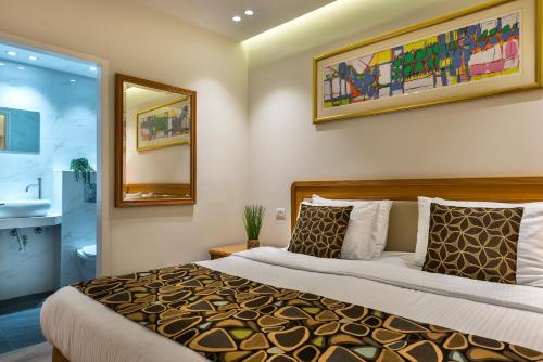 Melio Hotel Eilat في إيلات: غرفة نوم بسرير كبير ومرآة