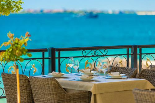 a table with chairs and wine glasses on a balcony at Onyx Beach Residence - Free Parking & Beach Access in Sveti Vlas