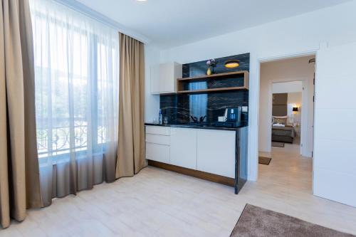 a living room with a kitchen with a large window at Onyx Beach Residence - Free Parking & Beach Access in Sveti Vlas