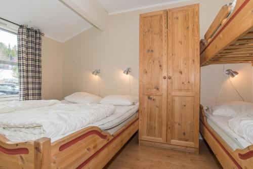 two twin beds in a room with a window at Skitorget Apartments in Trysil