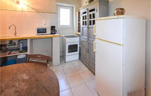 une cuisine avec un réfrigérateur blanc et une table dans l'établissement Cozy Apartment In Monteux With Wifi, à Monteux