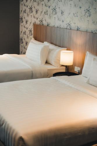 two beds sitting next to each other in a hotel room at Le'venue Hotel in Bangi