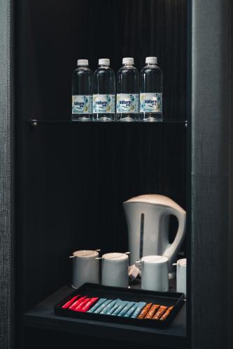 a shelf with several bottles of water and cups at Le'venue Hotel in Bangi