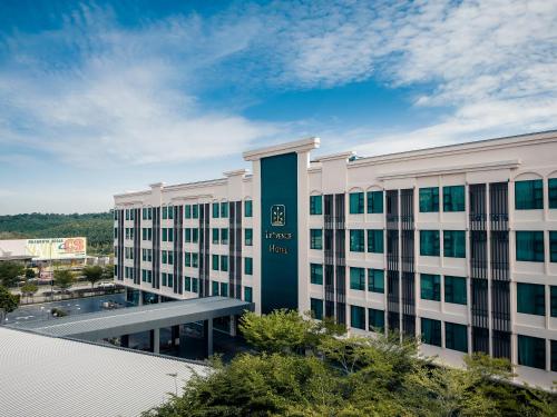 a large white building with a green sign on it at Le'venue Hotel in Bangi
