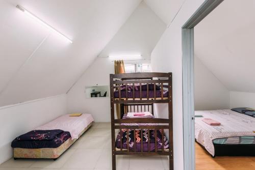 a attic room with two beds and a shelf at Amazing Grace Lodge in Kundasang