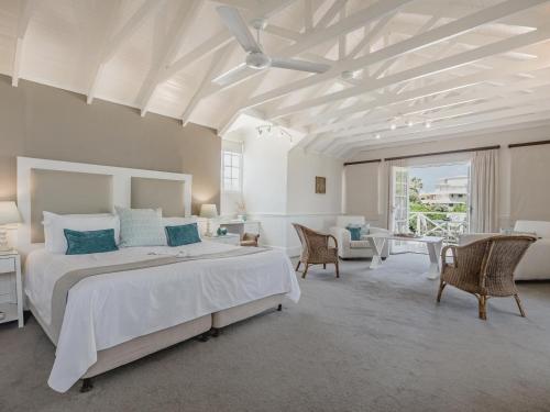 a bedroom with a large bed with a ceiling fan at Cottage Pie by Robberg in Plettenberg Bay