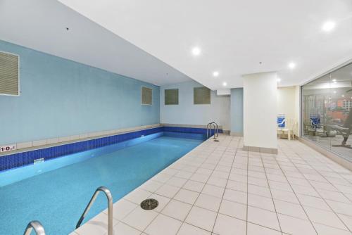 a swimming pool in a building with a tile floor at NAPI26N - Napier Vistas in Sydney