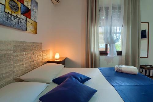 a bedroom with a bed with blue pillows and a window at Appartamento Asfodelo in Villacidro