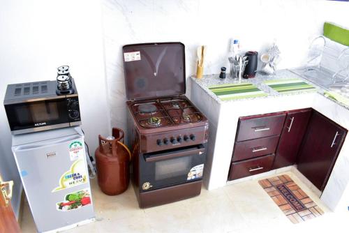 una pequeña cocina con fogones y nevera. en Rorot Spacious one bedroom in Kapsoya with free Wifi en Eldoret