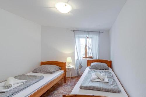 2 camas individuales en una habitación con ventana en Holiday house Črni Kal - Pri Roktovih, en Črni Kal