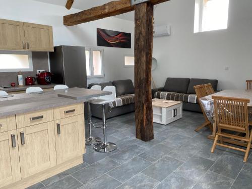 une cuisine et un salon avec un canapé et une table dans l'établissement La maison des biquettes, à Romorantin-Lanthenay