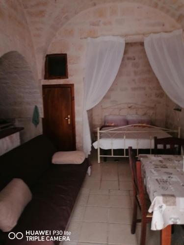 Kleines Zimmer mit einem Bett und einem Tisch in der Unterkunft La casa di Gina in Ceglie Messapica