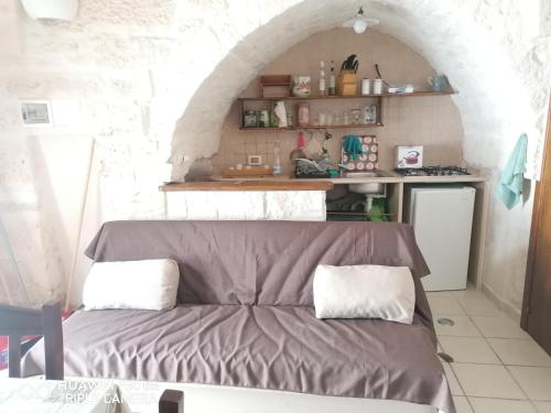 ein Zimmer mit einem Sofa in einer Küche mit einem Torbogen in der Unterkunft La casa di Gina in Ceglie Messapica