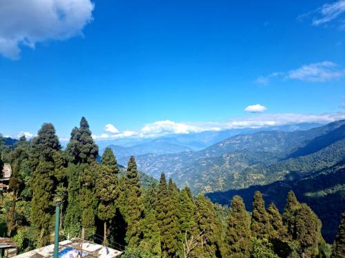 a view of a forest with mountains in the background at Neoravalley Homestay, Lava in Rishop