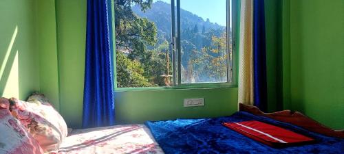 a bedroom with a window with a view of a mountain at Neoravalley Homestay, Lava in Rishop