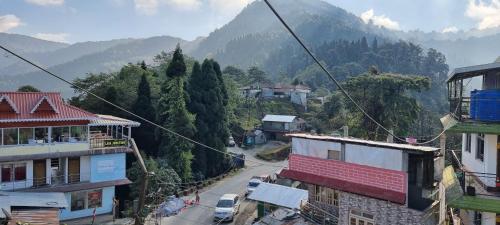 a view of a town with mountains in the background at Neoravalley Homestay, Lava in Rishop