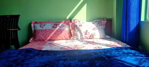 a bed with pink and blue sheets and pillows at Neoravalley Homestay, Lava in Rishop