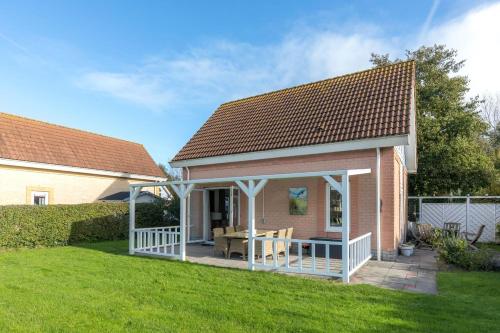 a small house with a porch and a patio at Villa-Meerchen-Villa-mit-ueberdachter-Terrasse-800m-vom-Strand-entfernt in Kamperland