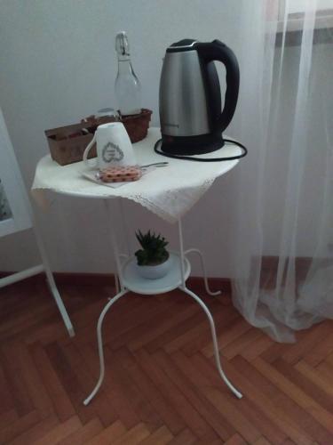 a white table with a tea kettle on top of it at Home Sweet Home Milano Malpensa Aereoporto in Cardano al Campo