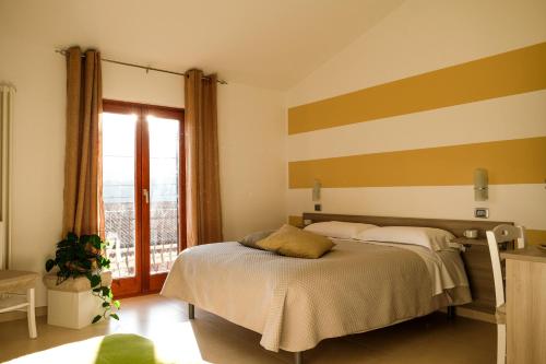a bedroom with a bed with a striped wall at L&B bed and breakfast in Terranova di Pollino