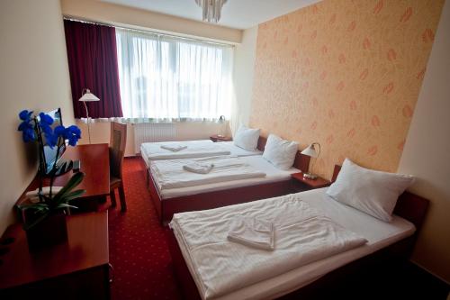 Canada Hotel Budapest tesisinde bir odada yatak veya yataklar