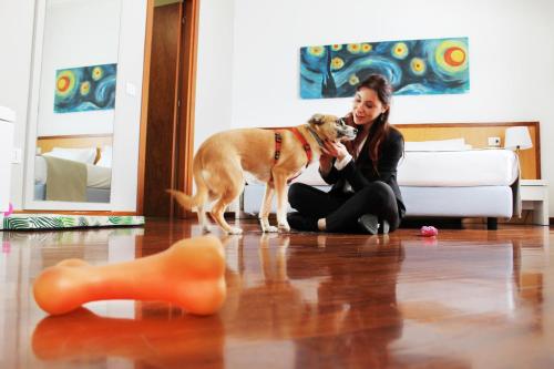 a woman sitting on the floor with a dog at Regiohotel Manfredi in Manfredonia