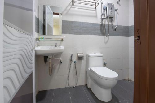 a bathroom with a toilet and a sink at OYO 90380 Hotel Jasin in Jasin