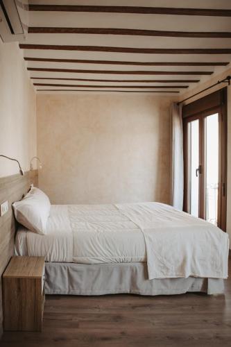 a bedroom with a large white bed and a window at Hospedium Aloque BOUTIQUE PLAZA in Valdepeñas