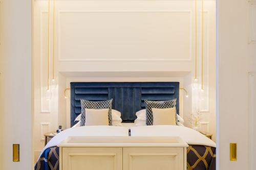 a bedroom with a large bed with a blue headboard at Excelsior Hotel Ernst am Dom in Cologne