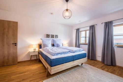 1 dormitorio con cama con sábanas azules y ventana en Ferienwohnung Max, en Gilching