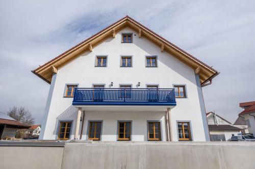 a white house with a blue balcony at Ferienwohnung Maria in Gilching