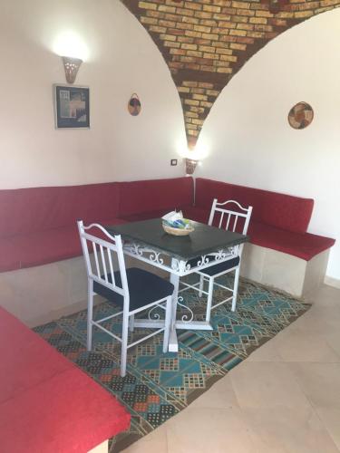 a dining room with a table and two chairs at The Brown House in Luxor