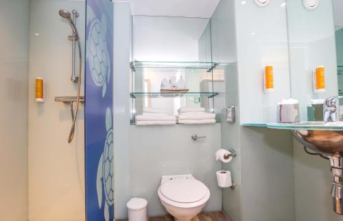 a small bathroom with a toilet and a sink at Holiday Inn Bournemouth by IHG in Bournemouth
