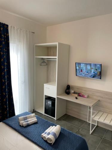 Habitación con TV y cama con toallas. en Alghero VitAlba, en Alghero