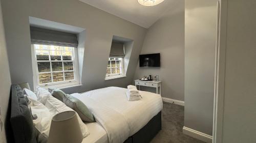 1 dormitorio con 1 cama grande y 2 ventanas en Dockers Inn, en Londres