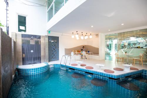 a house with a swimming pool in the middle of it at Nimman Mai Design Hotel Chiang Mai - SHA Plus in Chiang Mai