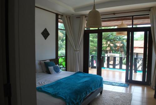 a bedroom with a bed and a large window at RED PEARL BEACH RESORT in Chaloklum