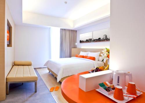 ein Schlafzimmer mit einem Bett und einem Tisch in einem Zimmer in der Unterkunft HARRIS Hotel & Conventions Gubeng in Surabaya